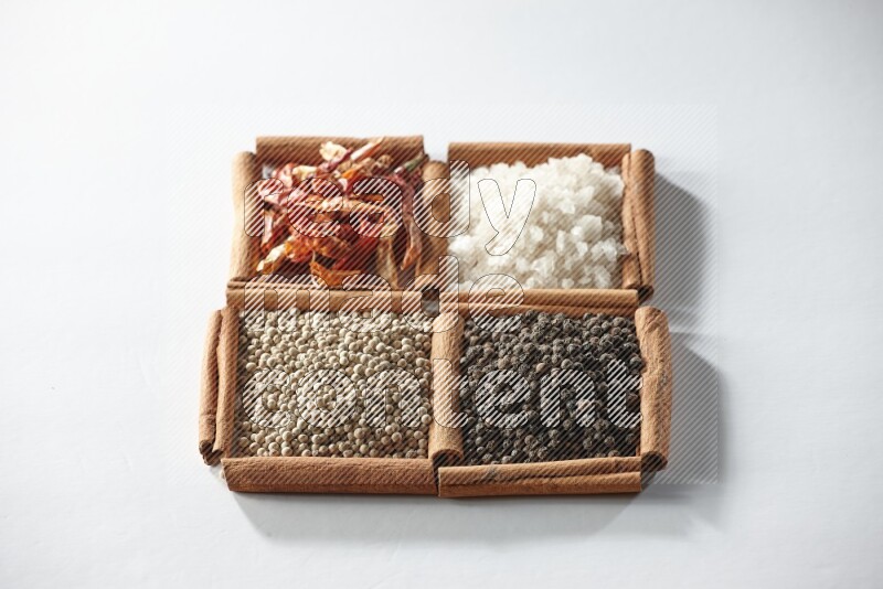 4 squares of cinnamon sticks full of red chilis, salt, white pepper, and black pepper on white flooring