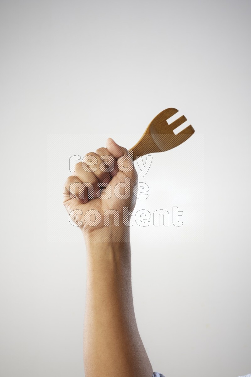 Male Hand Holding Wooden Fork on white  background