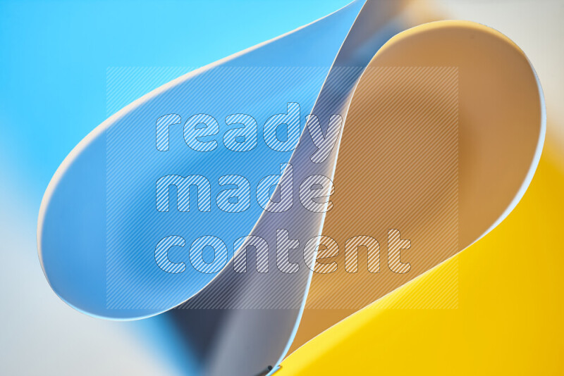 An abstract art of paper folded into smooth curves in blue and yellow gradients