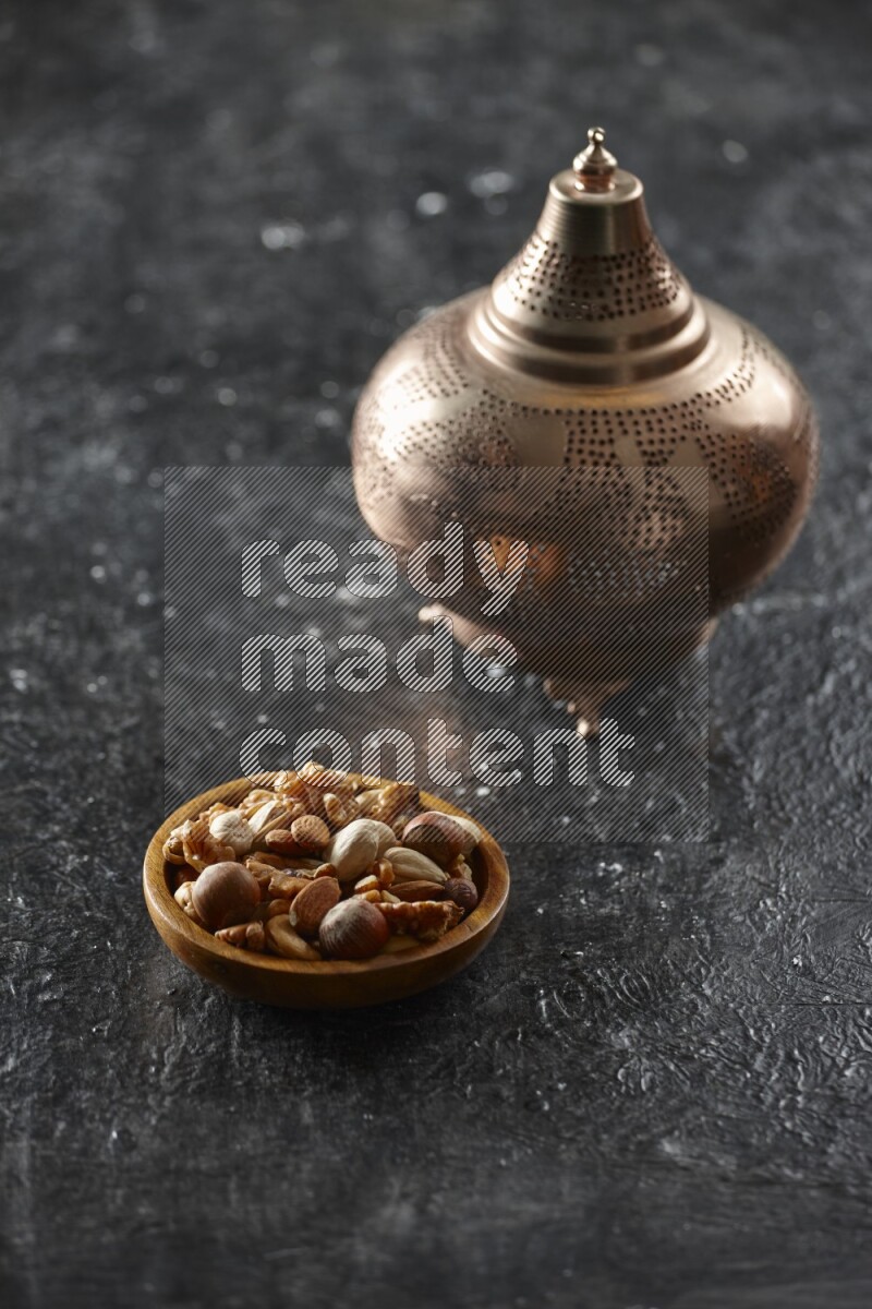 A golden lantern with different drinks, dates, nuts, prayer beads and quran on textured black background