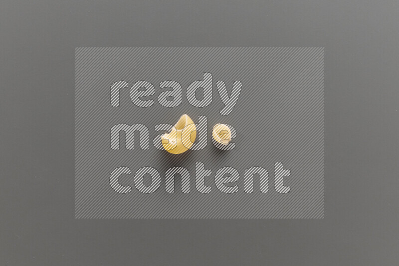 Pipe pasta with other types of pasta on grey background