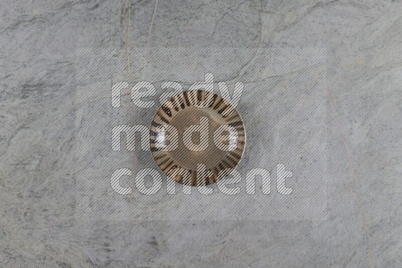 A multicolored pottery plate on grey marble background