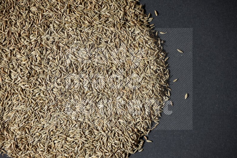 Cumin seeds on black flooring