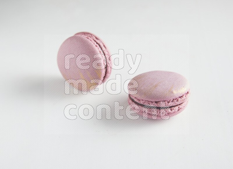 45º Shot of two Purple Strawberry macarons on white background