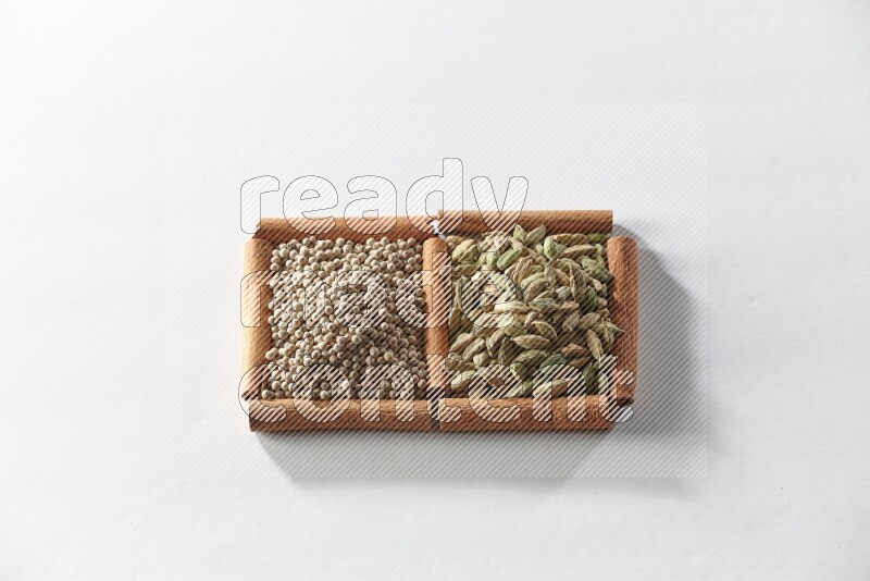 2 squares of cinnamon sticks full of cardamom and white pepper on white flooring