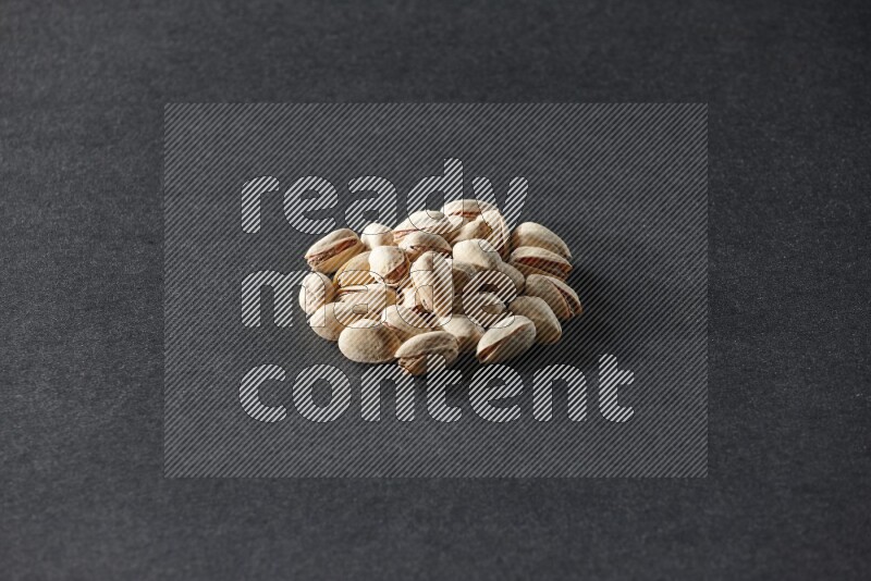 A bunch of pistachios on a black background in different angles