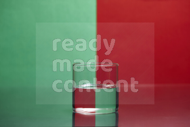 The image features a clear glassware filled with water, set against green and red background