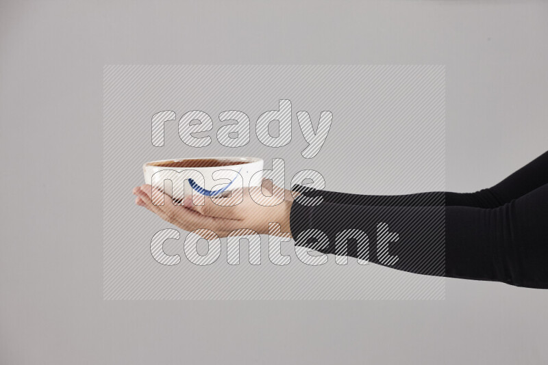 A woman in black abaya holding different pottery essentials in different positions