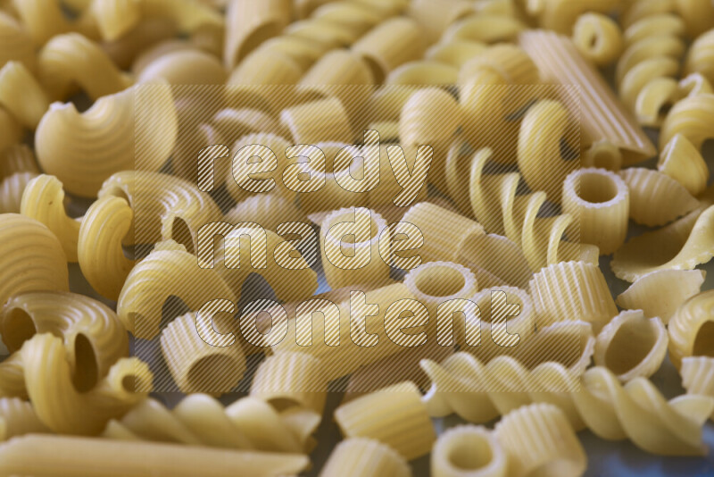 Different pasta types on light blue background