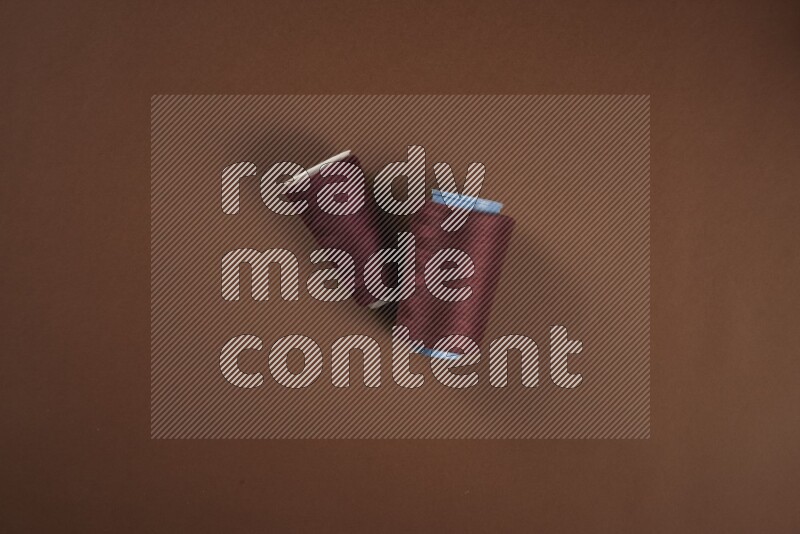 A red collection of sewing and tailoring tools arranged on a brown background