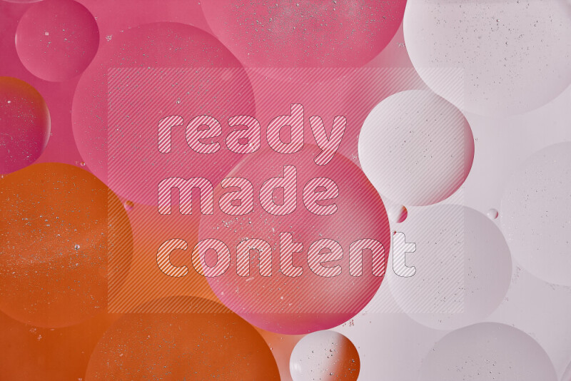 Close-ups of abstract oil bubbles on water surface in shades of white, orange and pink