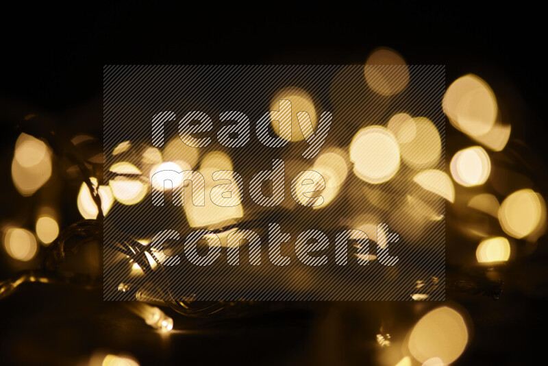 Light bulbs glowing against backdrop of golden bokeh