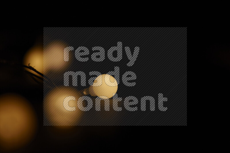 Light bulbs glowing against backdrop of golden bokeh