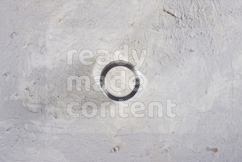 A glass jar full of coarse sea salt crystals on white background
