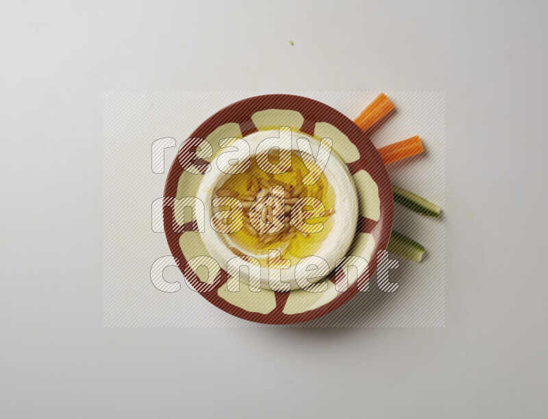 Lebnah garnished with pine nuts in a traditional plate on a white background