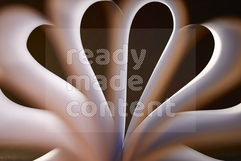 An abstract art piece displaying smooth curves in white and orange gradients created by colored light