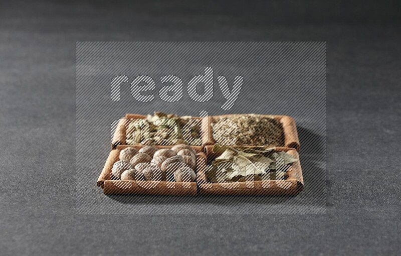4 squares of cinnamon sticks full of cumin, cardamom, bay laurel leaves and nutmegs on black flooring
