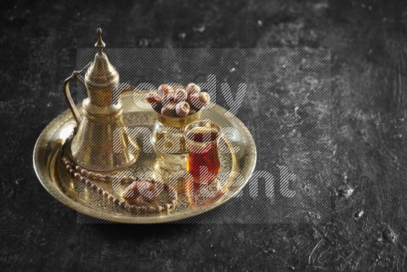 Dates with a drink on a metal tray in a dark setup