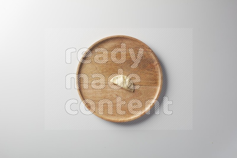 A single Sambosa on a wooden round plate on a white background