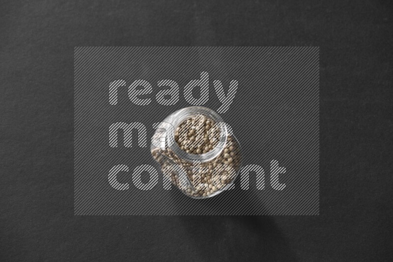 فلفل أبيض في وعاء زجاجي علي خلفية سوداء