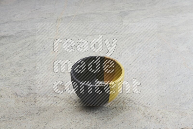 A multicolored pottery bowl on grey marble background