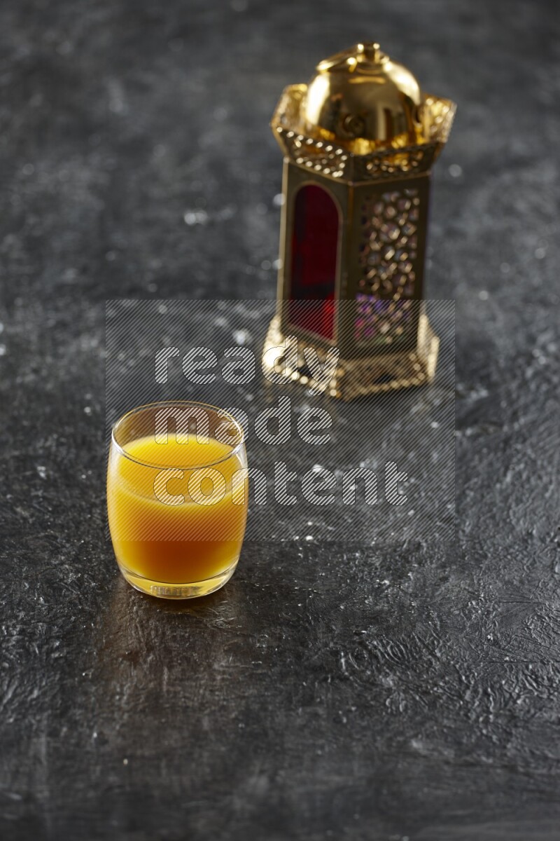 A golden lantern with different drinks, dates, nuts, prayer beads and quran on textured black background