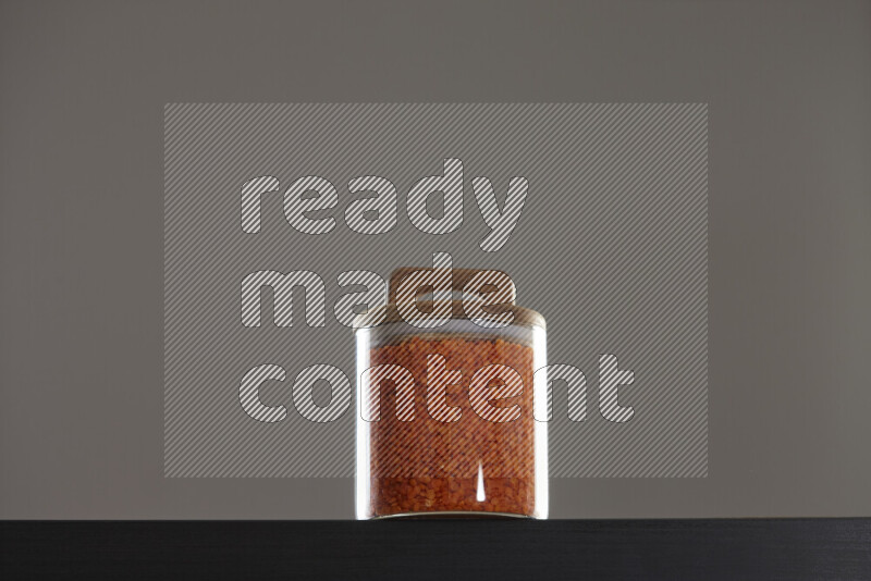 Lentils in a glass jar on black background