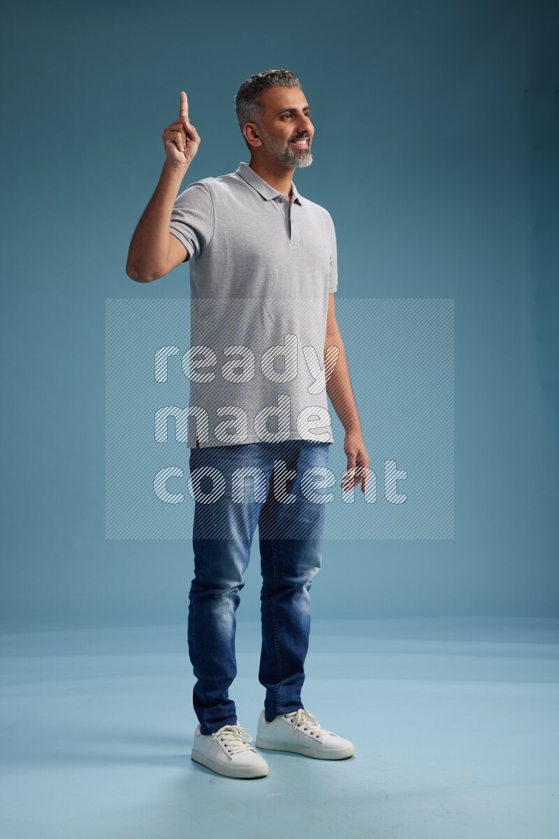 Man Standing Interacting with the camera on blue background