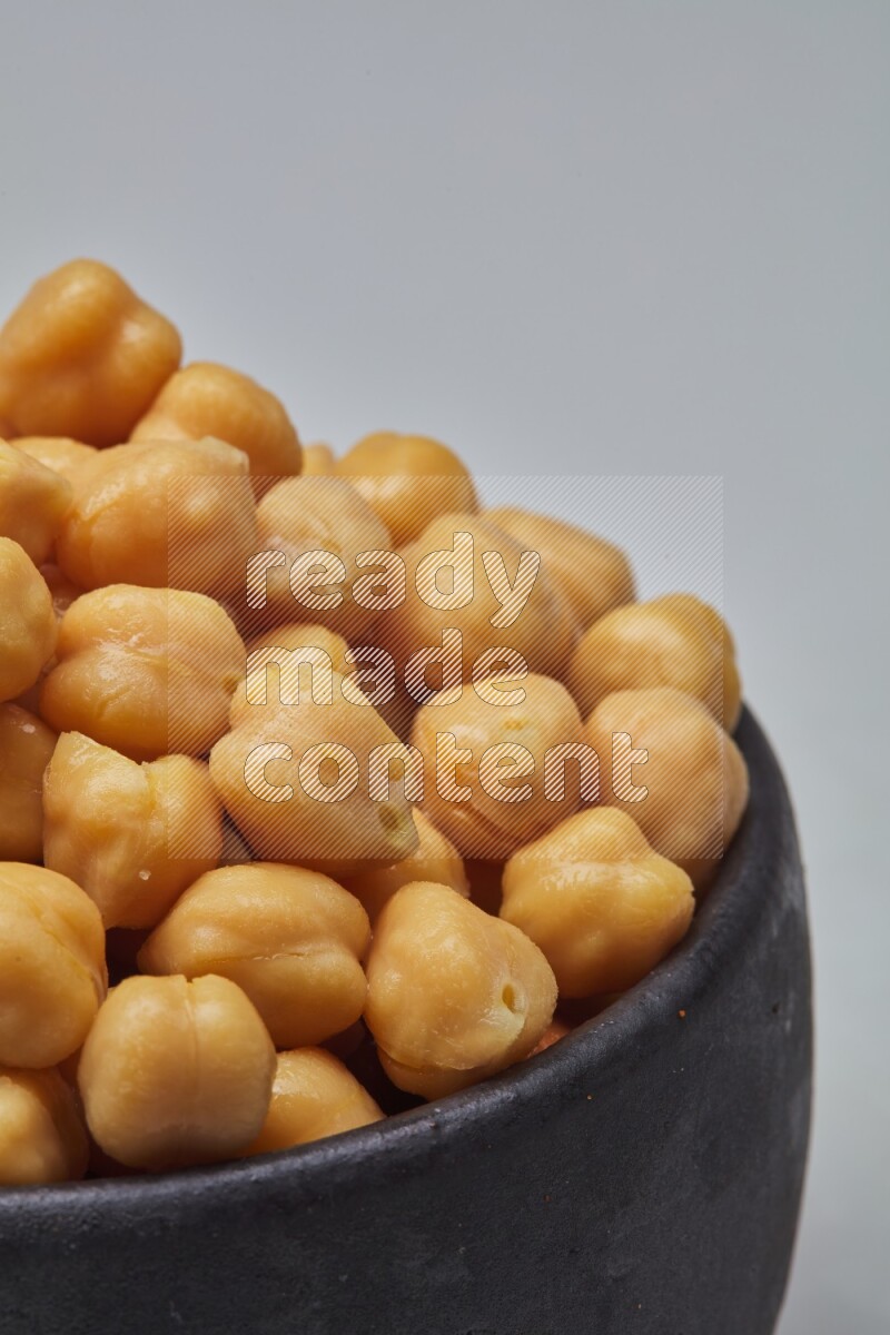 Close up shot of boiled chickpeas in a container on white background