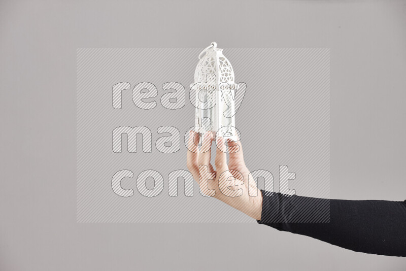 امرأة ترتدي عباءة سوداء تحمل فوانيس رمضانية مختلفة في أوضاع متعددة