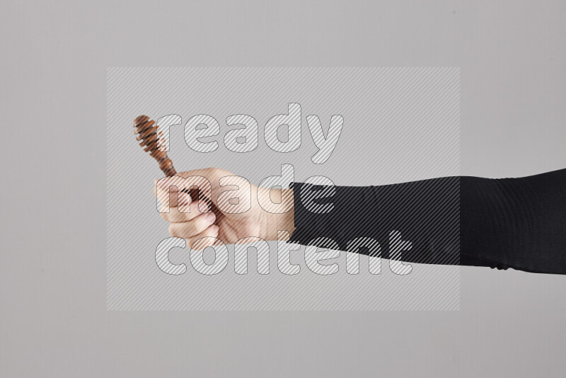 امرأة ترتدي عباءة سوداء تحمل أدوات خشبية مختلفة في أوضاع متعددة