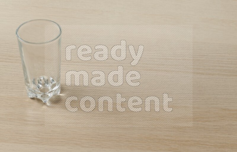 An empty glass cup on light wooden background