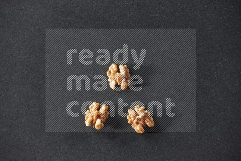 3 walnuts on a black background in different angles