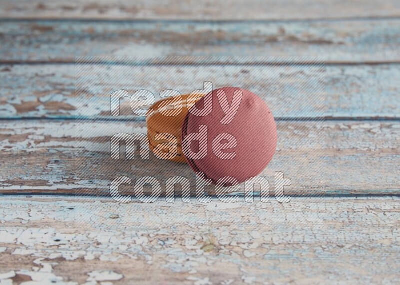 45º Shot of of two assorted Brown Irish Cream, and Red Cherry macarons  on light blue background