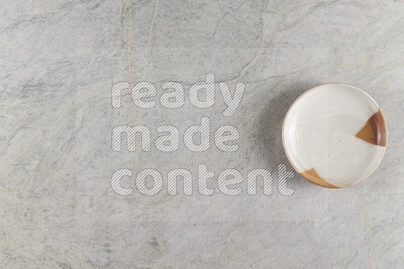 A decorative pottery plate on grey marble background