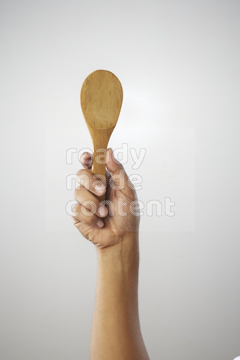 Male Hand Holding Wooden spoon on white background