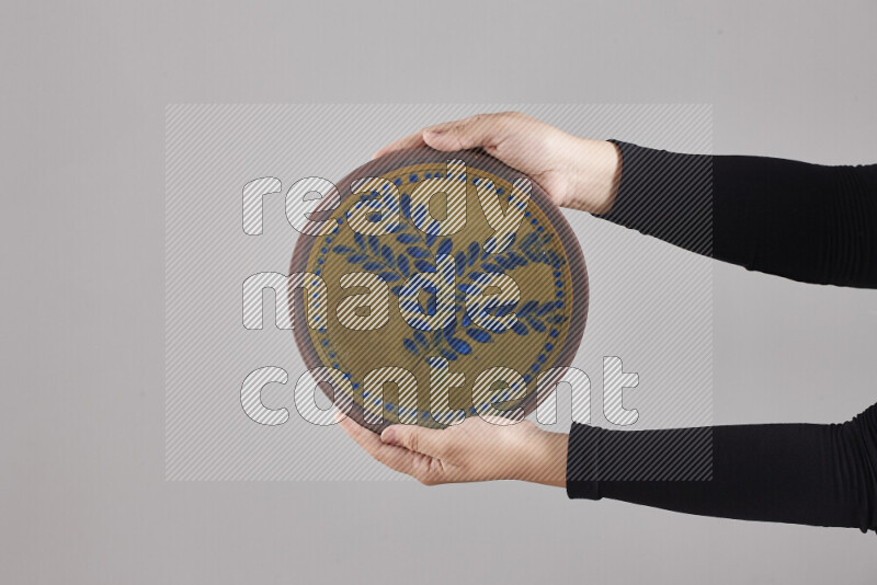 A woman in black abaya holding different pottery essentials in different positions