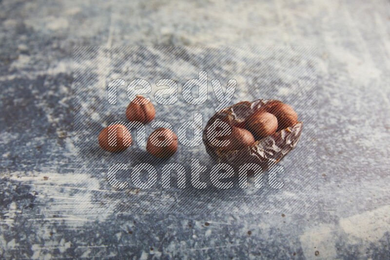 hazelnuts stuffed majdoul date on a rustic blue background