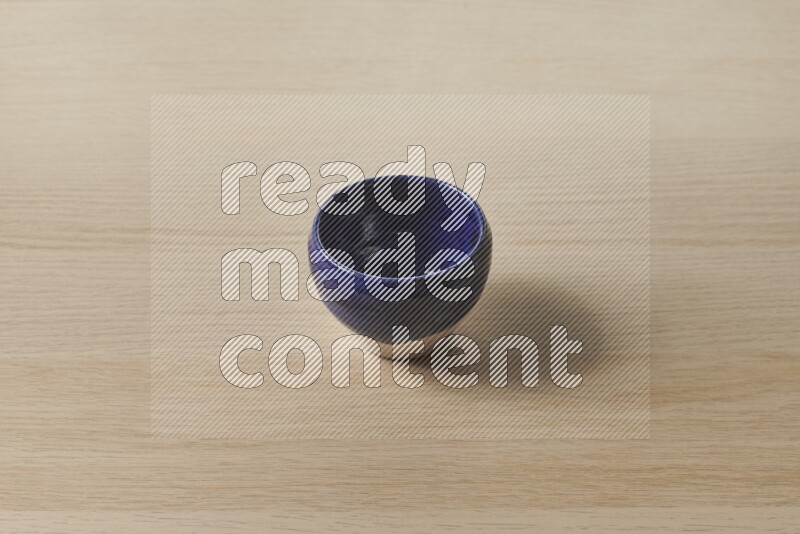 A multicolored pottery bowl on light wooden background