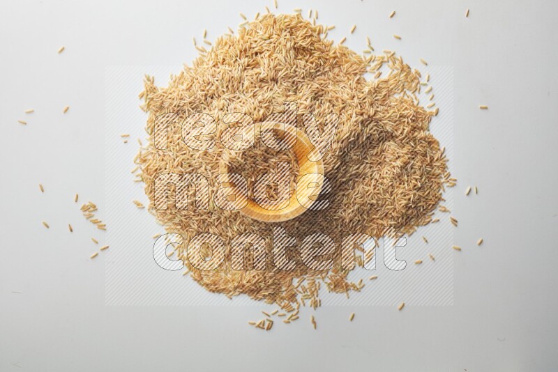Top-view shot of long grain brown rice in a container on white background