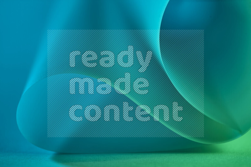 فن تجريدي يعرض منحنيات وتدرجات اللون الأخضر والأزرق مكونه بضوء ملون