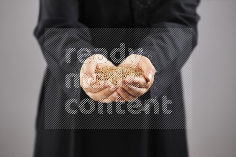 Woman in abaya holding different kinds of spices in different positions