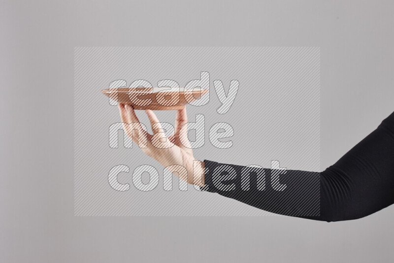 A woman in black abaya holding different pottery essentials in different positions