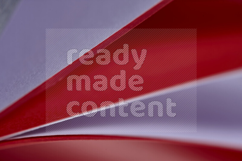 An abstract art showing purple and red paper sheets arranged in an overlapping curves