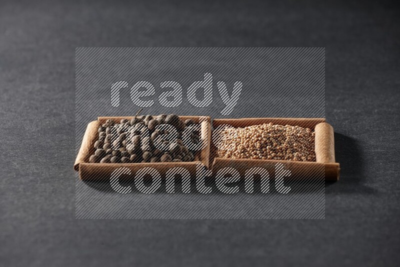 2 squares of cinnamon sticks full of mustard seeds and allspice on black flooring