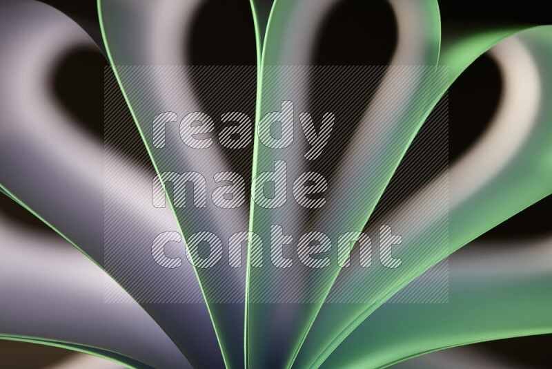 An abstract art piece displaying smooth curves in white and green gradients created by colored light