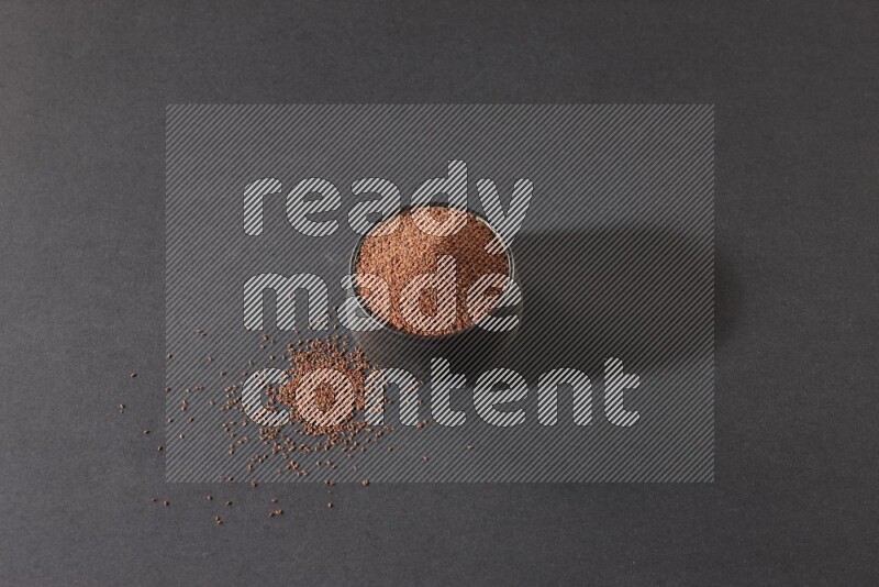 وعاء فخاري أسود ممتلئ ببذور حب الرشاد على أرضية سوداء