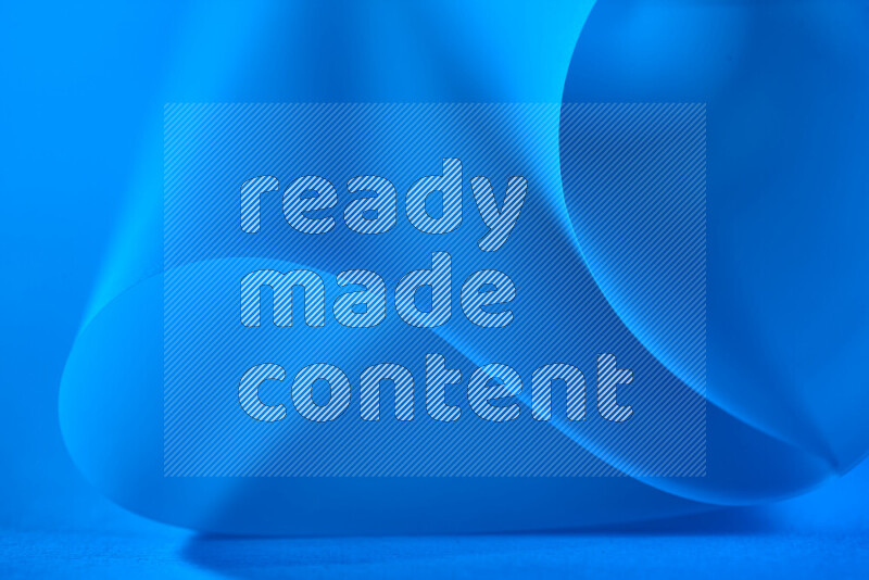 An abstract art piece displaying smooth curves in blue gradients created by colored light