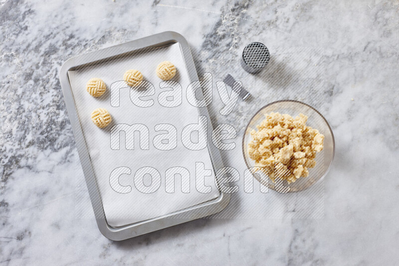 Kahk step by step with its ingredients ghee, sugar, flour, sesame, yeast, water and kahk flavor on grey marble background