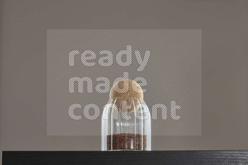 Flax seeds in a glass jar on black background